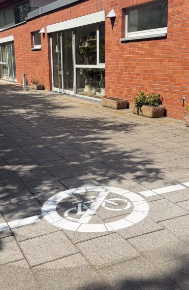 Ein Gehweg mit einem Fahrradverbotsschild auf den Pflastersteinen.